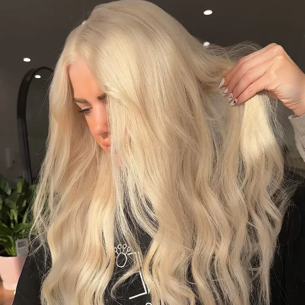 A woman with long blonde hair is holding her hair in a ponytail — Lavie Hair & Beauty in Ciccone, NT