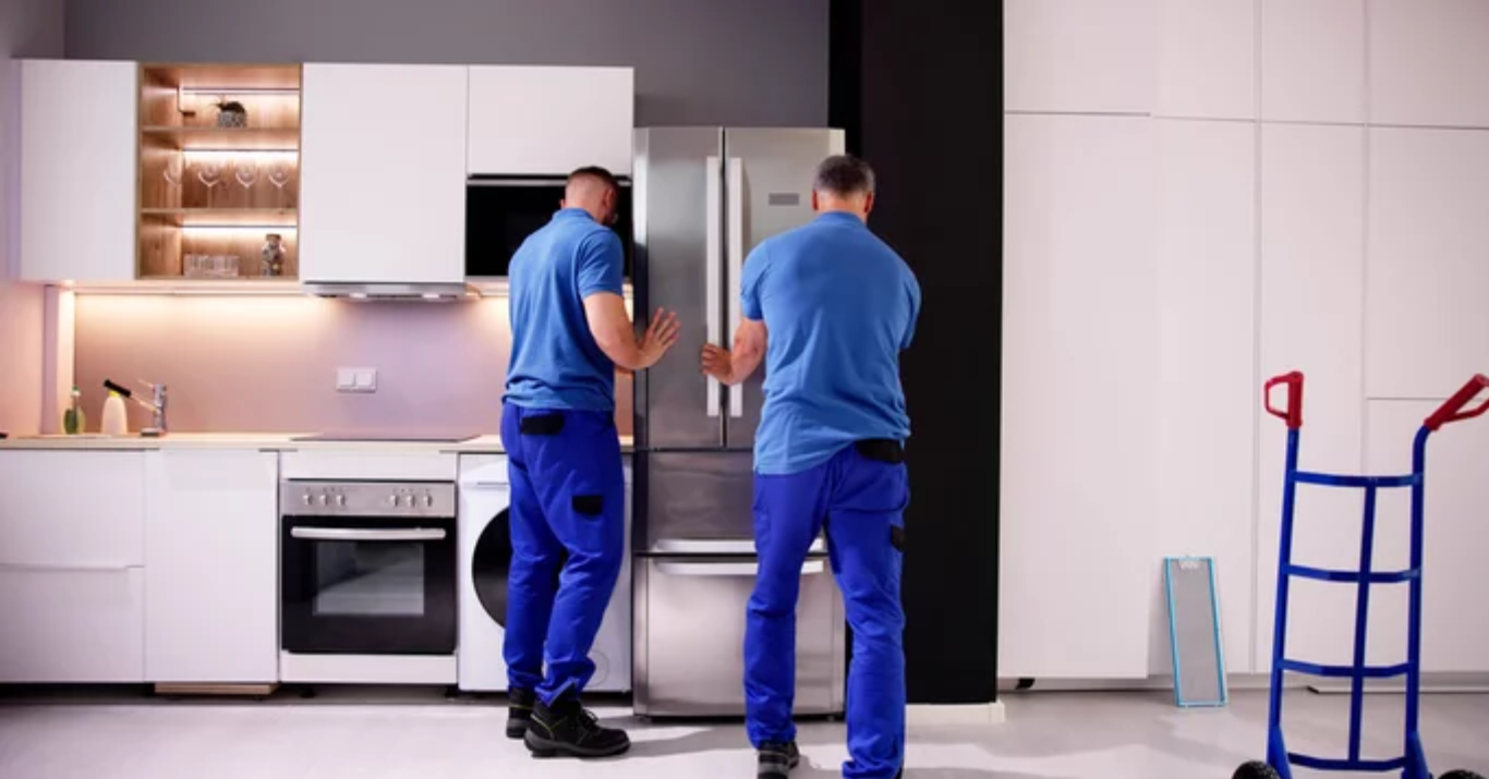 Professional delivery and installation of a modern refrigerator appliance in a stylish kitchen setting.