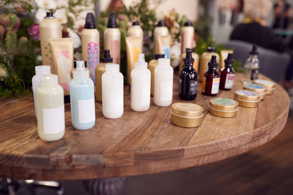 A wooden table topped with bottles of hair products.