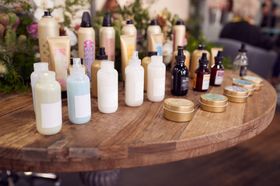 A wooden table topped with bottles of hair products.