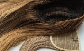 A close up of a wig on a white surface.