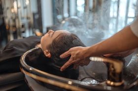 A woman is getting her hair washed in a sink at a salon.