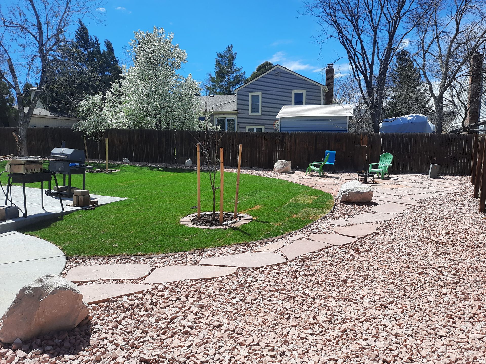 A backyard with a fire pit and a house in the background