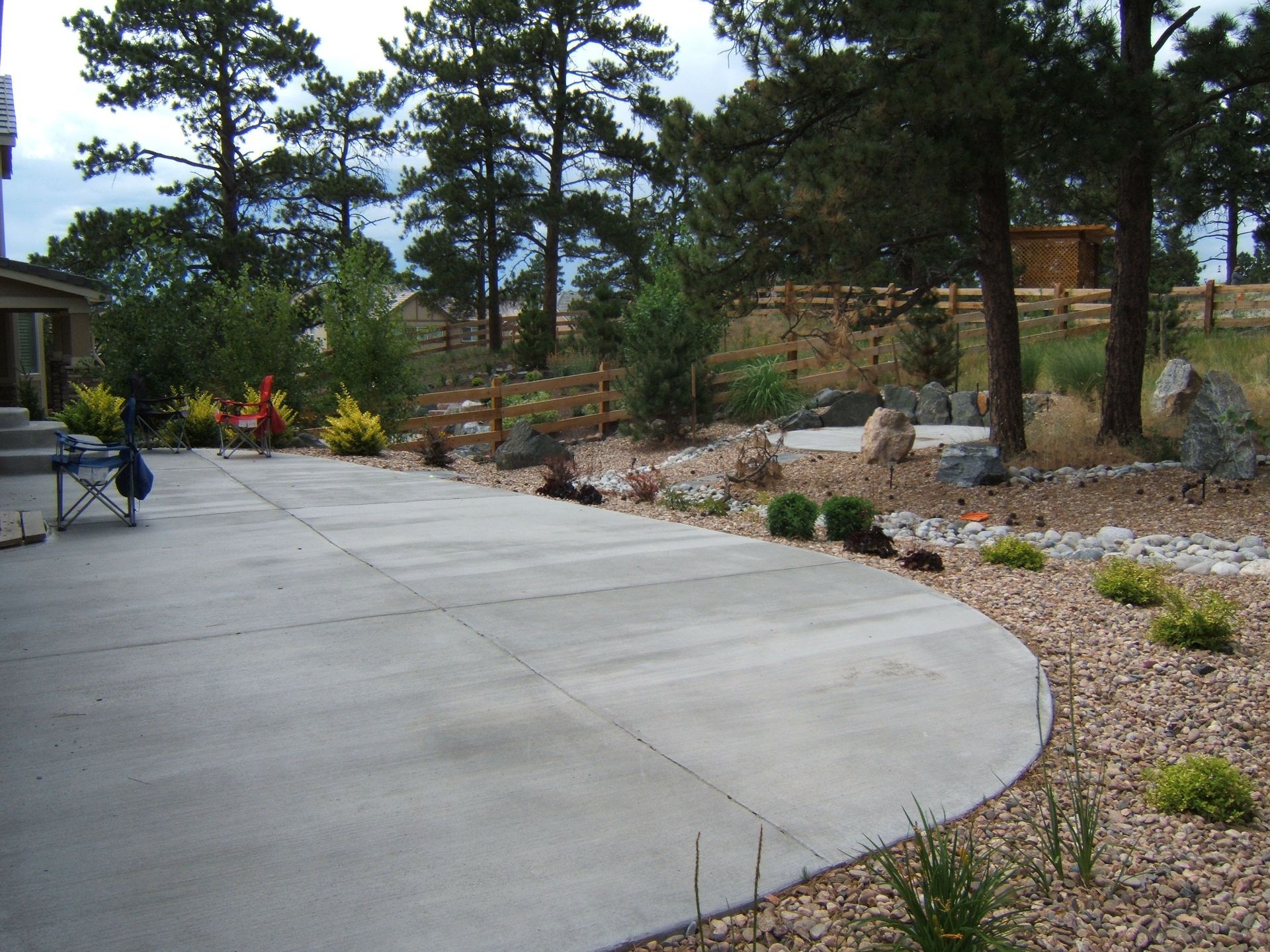 A concrete driveway with a fence in the background