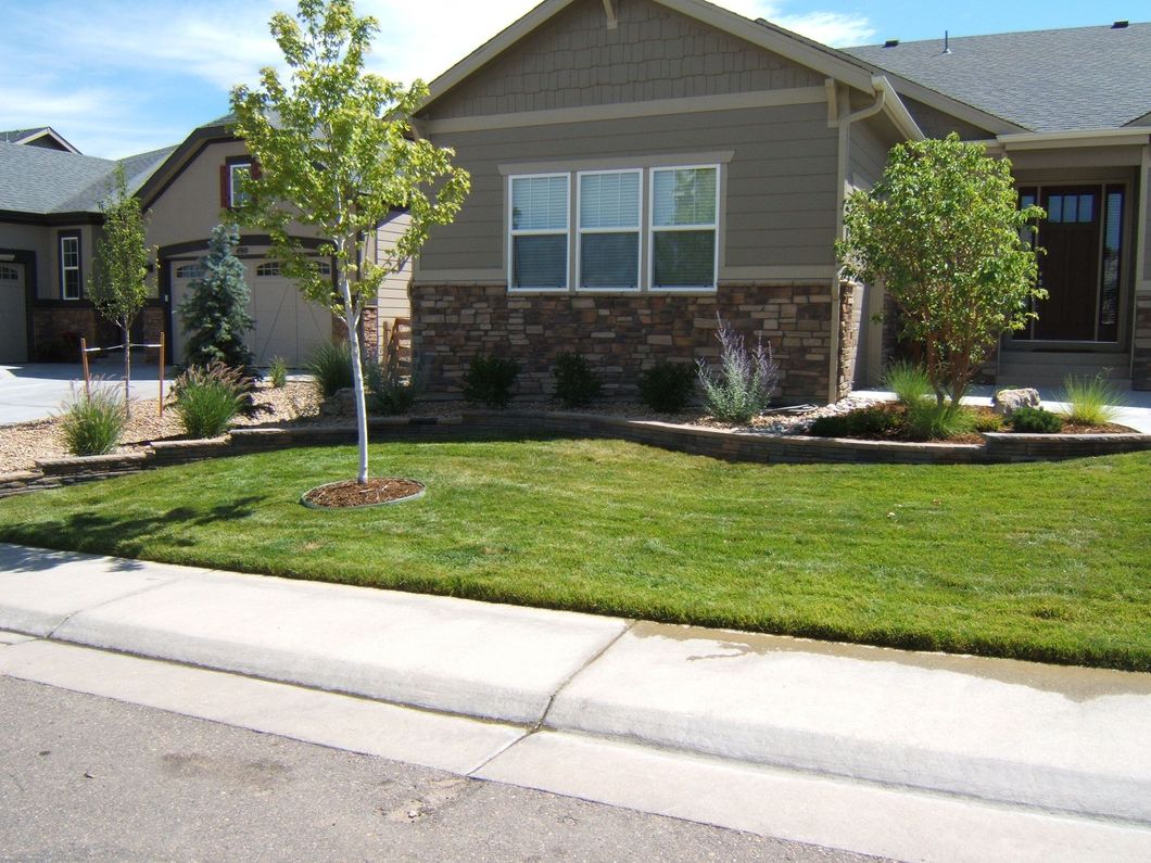 A house with a lush green lawn in front of it