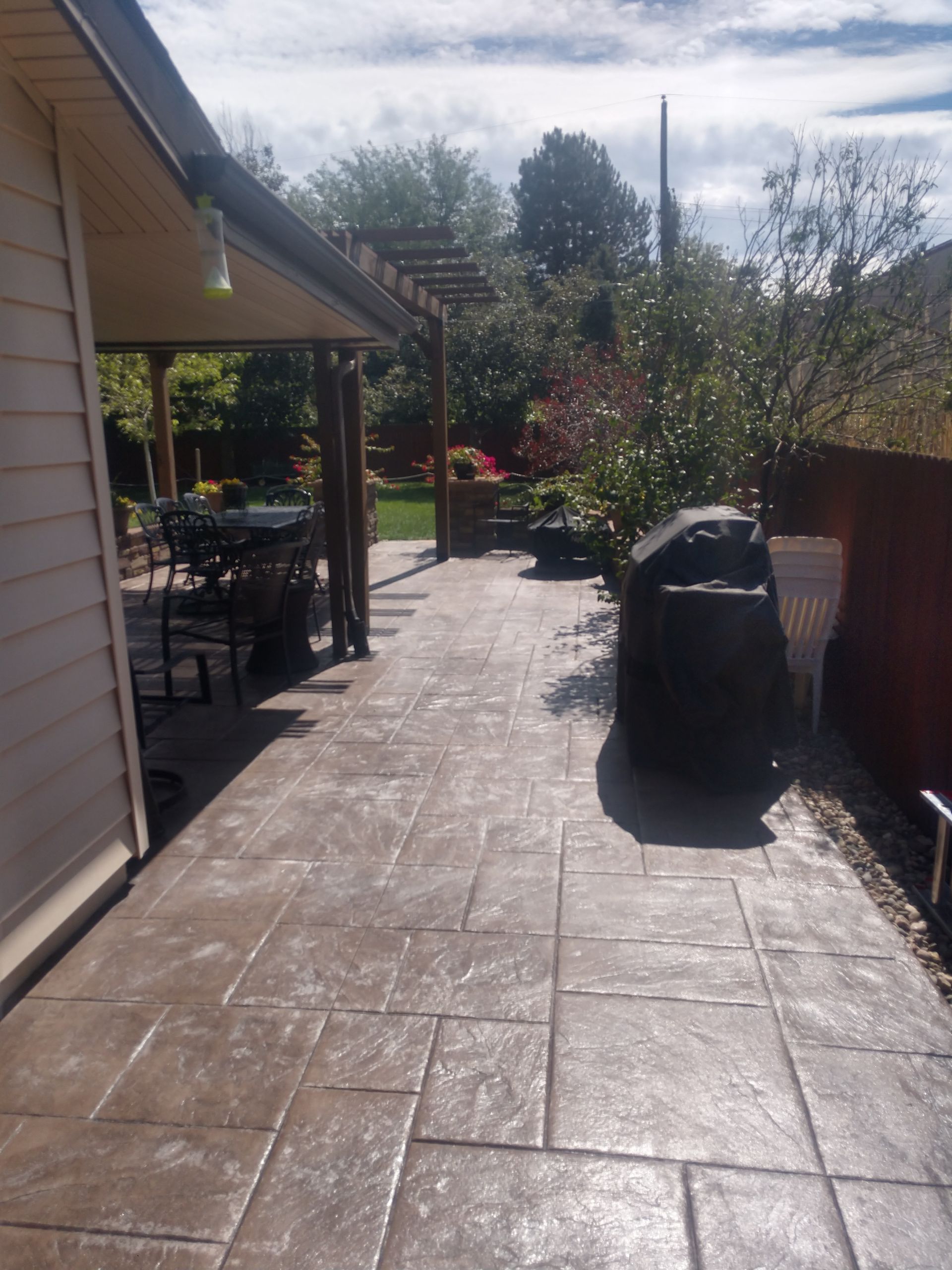 A patio with a grill in the backyard of a house