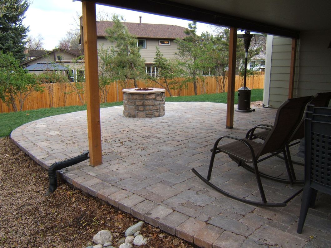 A patio with rocking chairs and a fire pit