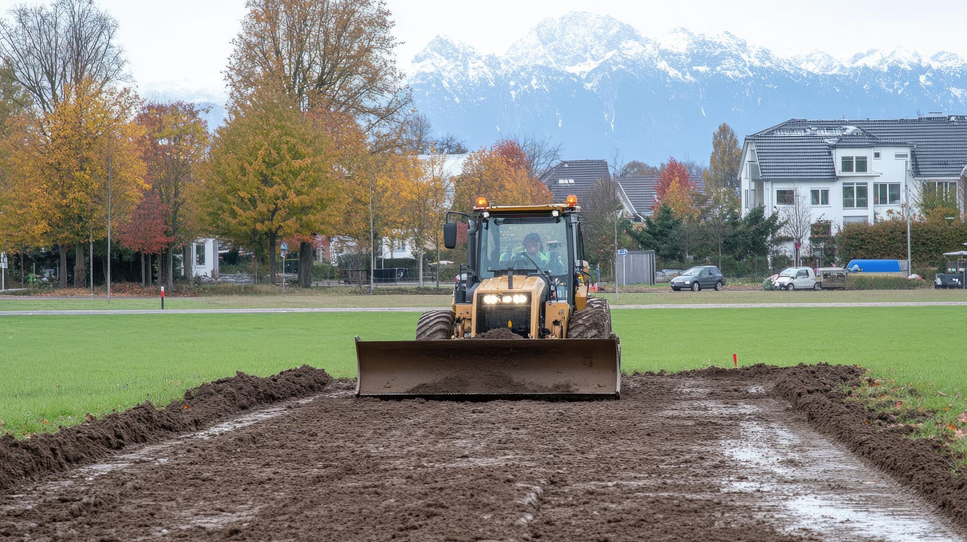 A bulldozer is driving through a muddy field.