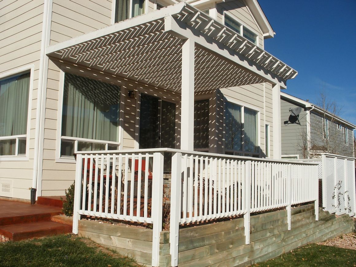 A white house with a porch with a canopy over it