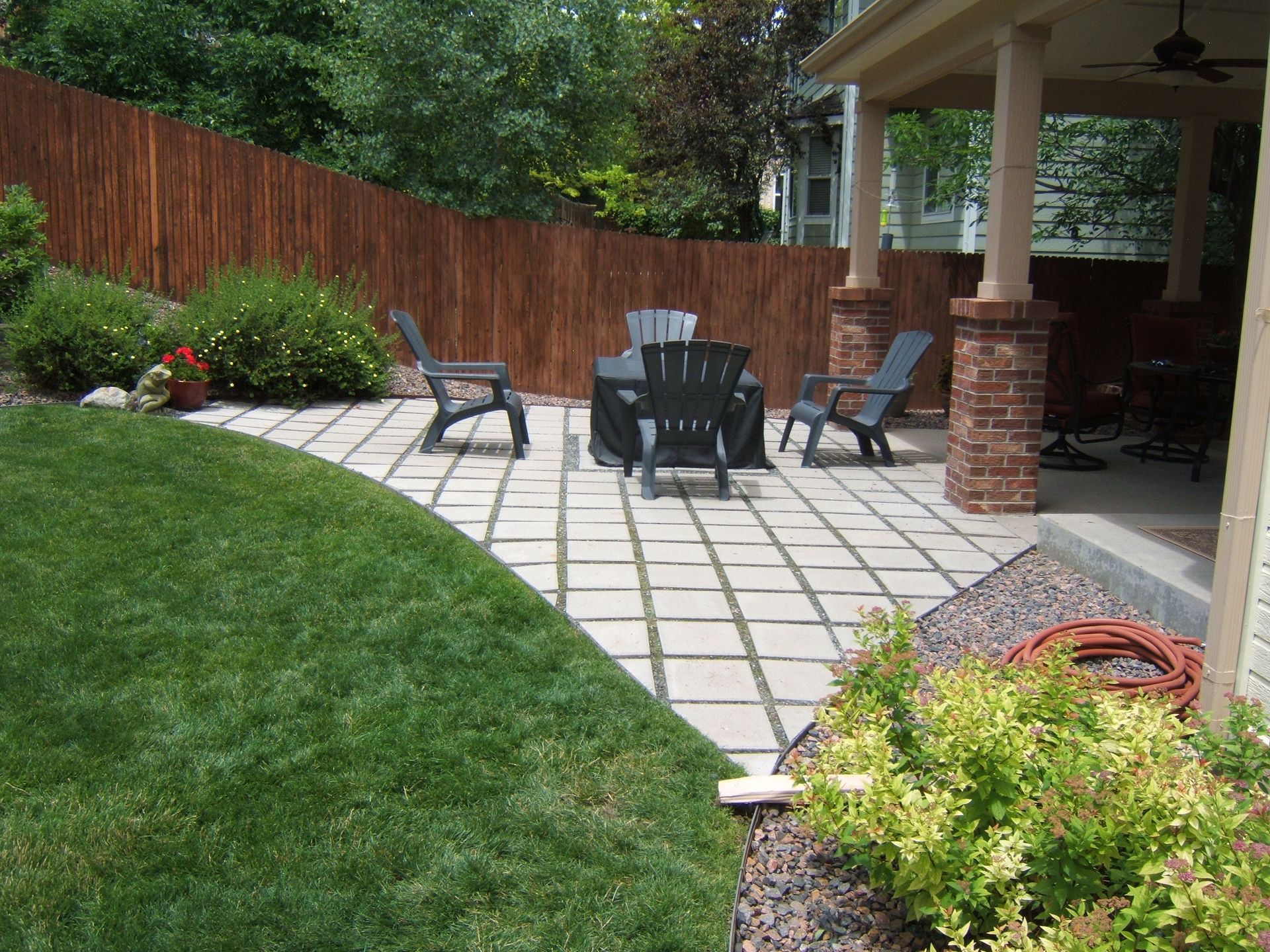 A patio with a table and chairs in the backyard