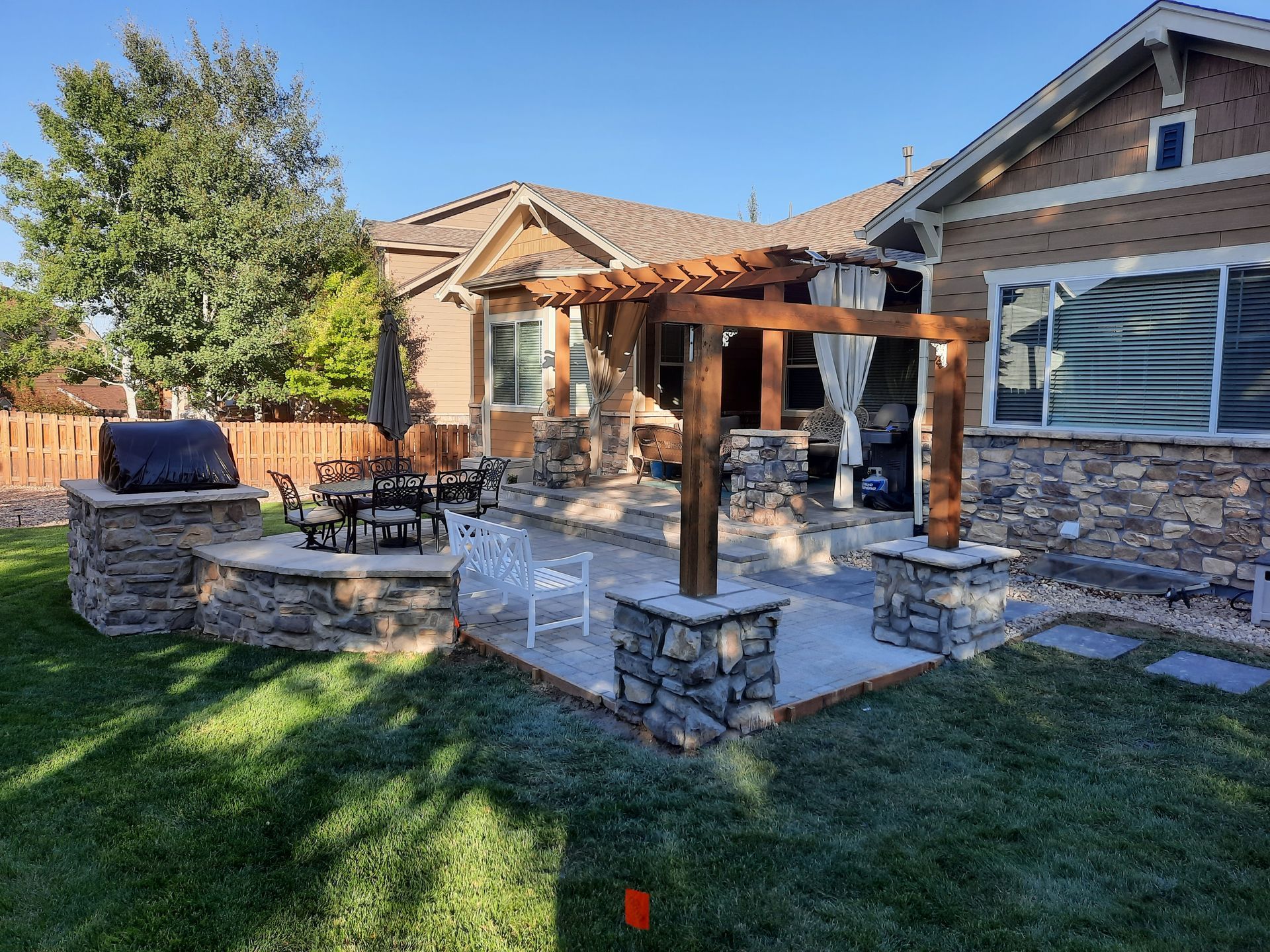 There is a pergola in the backyard of a house.