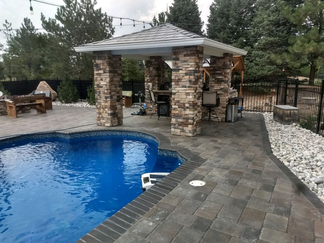 A large swimming pool with a gazebo in the background