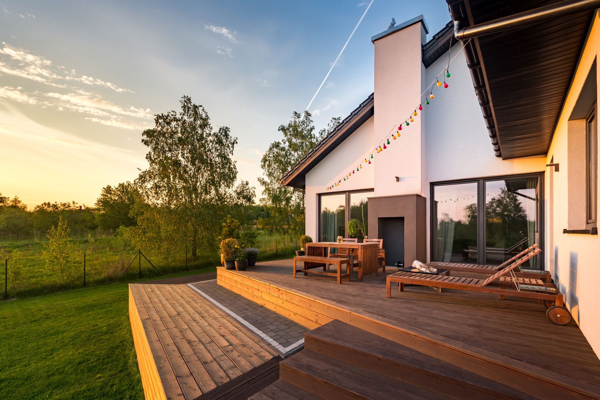A large white house with a wooden deck in front of it.