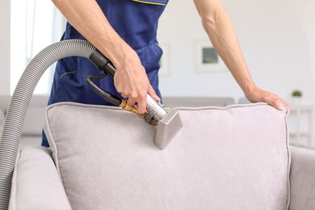 A Woman Is Kneeling On The Floor Cleaning A Carpet With A Spray Bottle — Echo Carpet Cleaning In Wauchope, NSW
