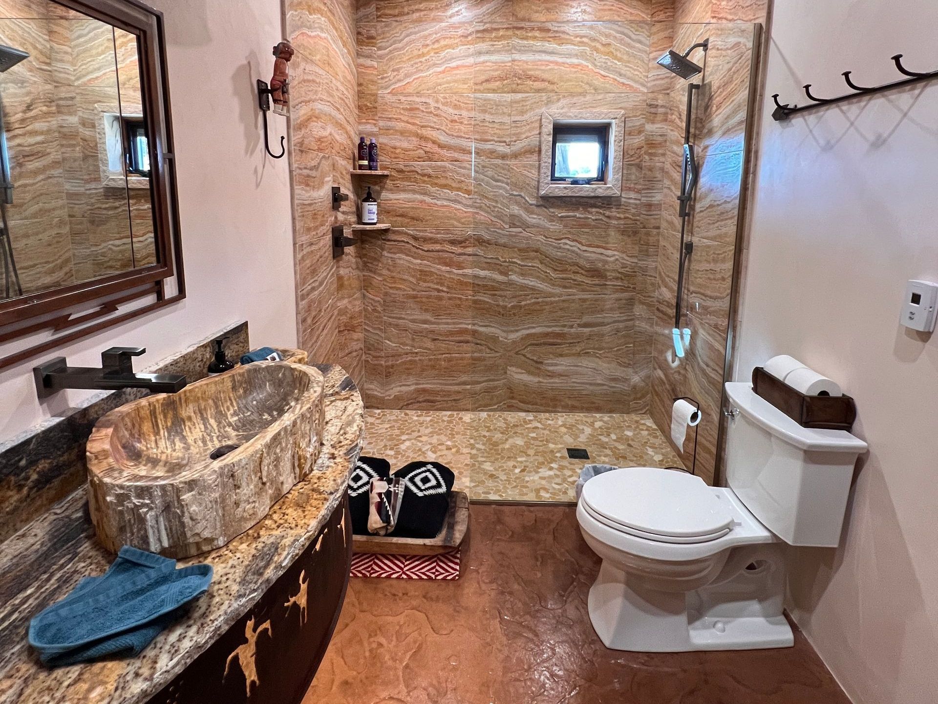 A bathroom with a sink , toilet , shower and mirror.