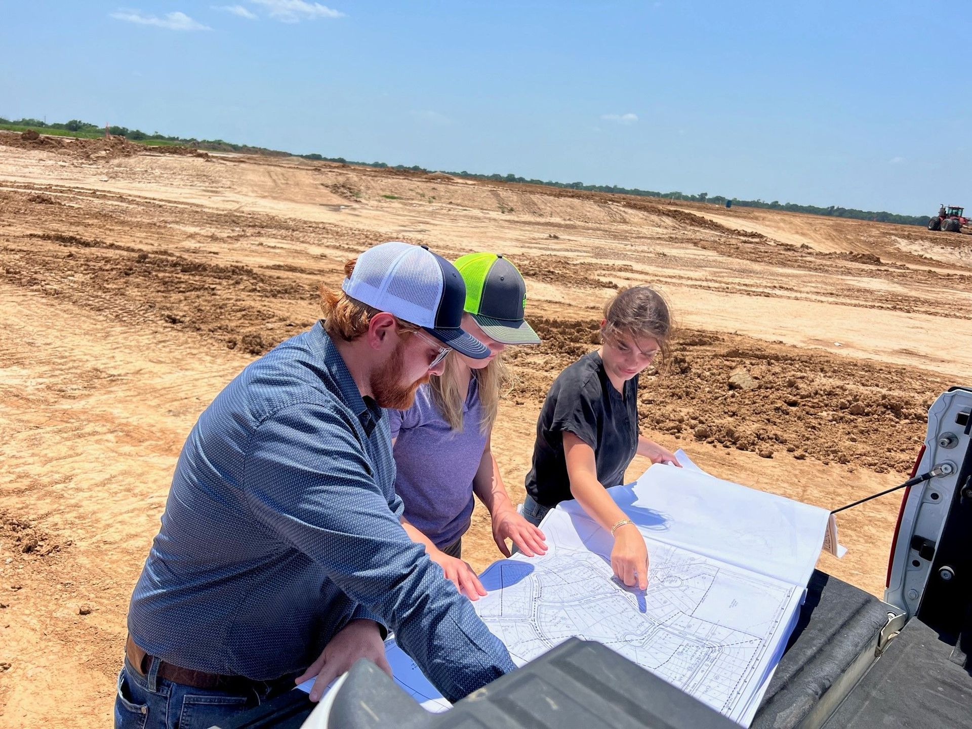 Intern in the field with coworkers looking at map