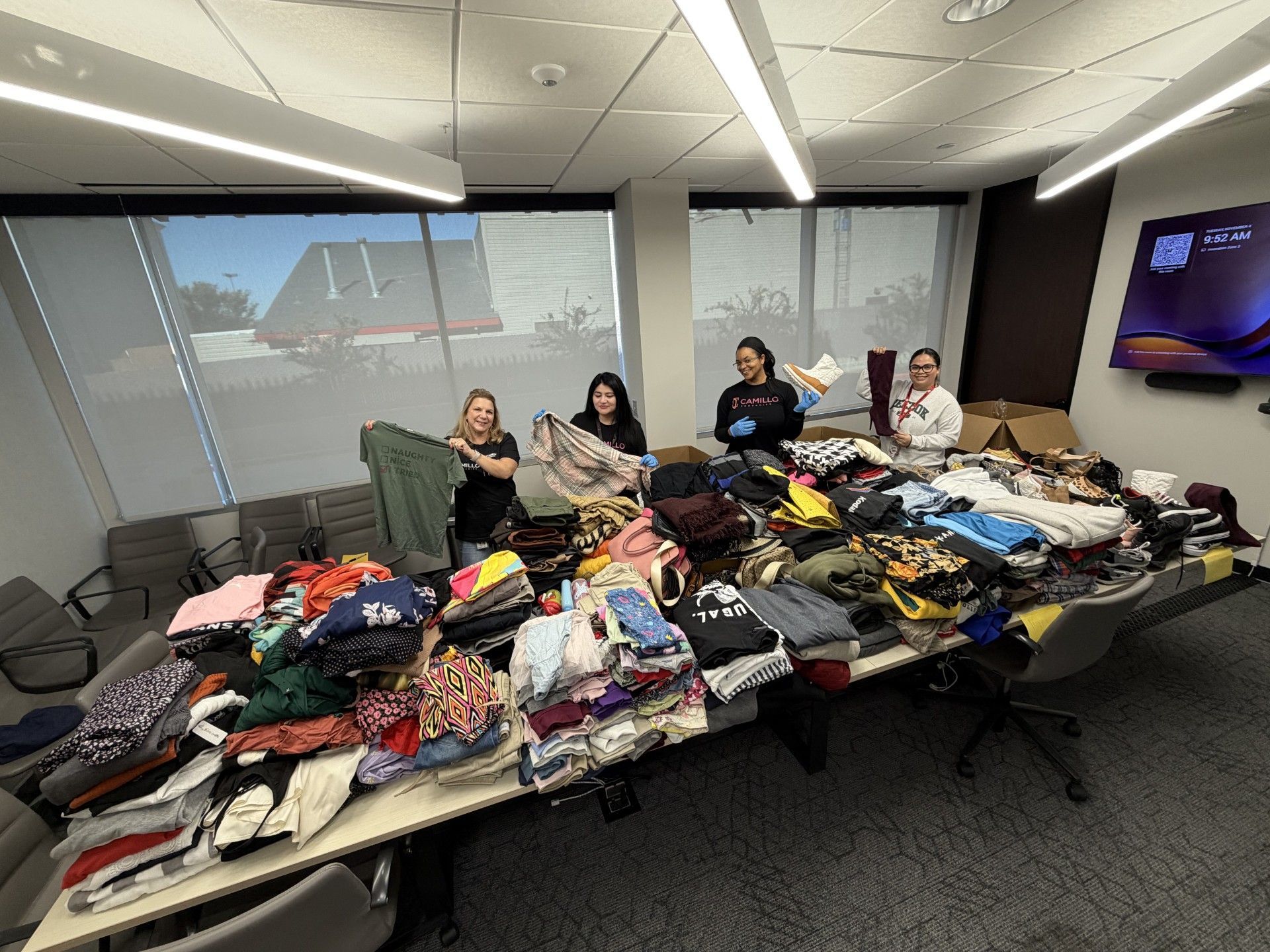 Camillo Companies employees showcasing clothing donated