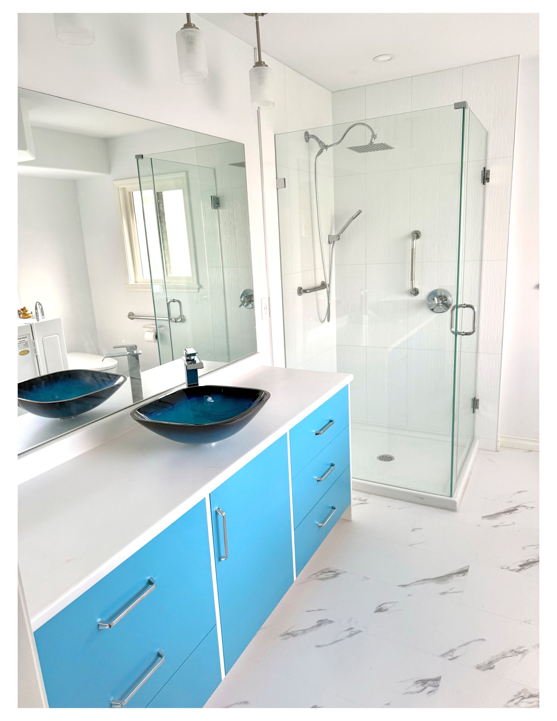 A bathroom with two sinks and a walk in shower