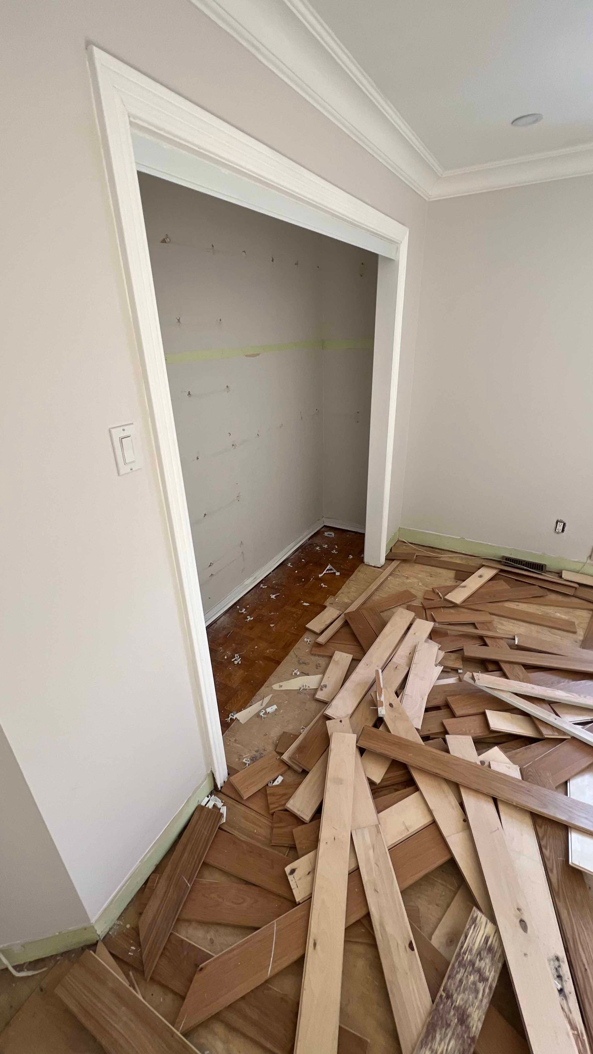 A room with a lot of wood on the floor and a doorway.