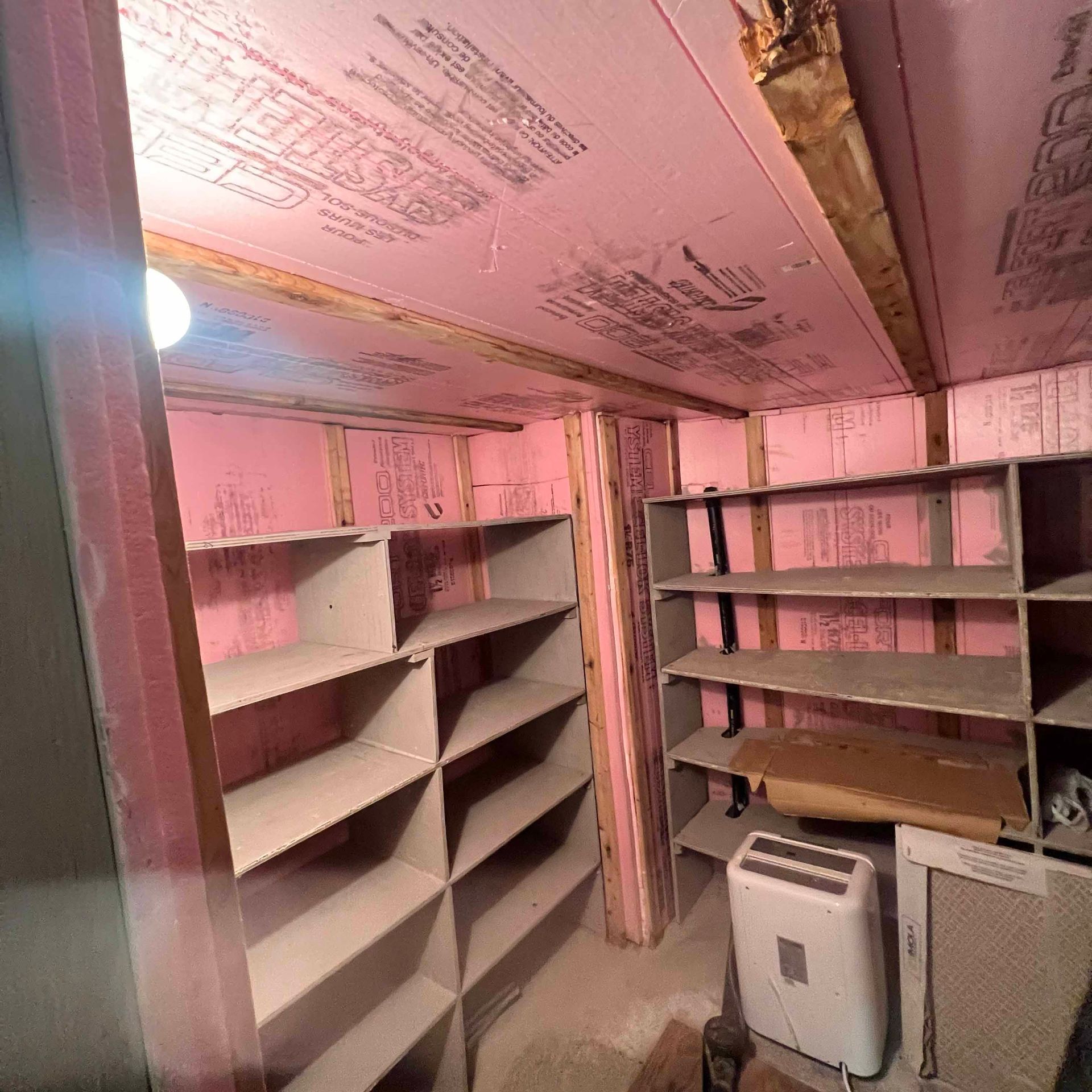 A room with pink walls and shelves and an air conditioner