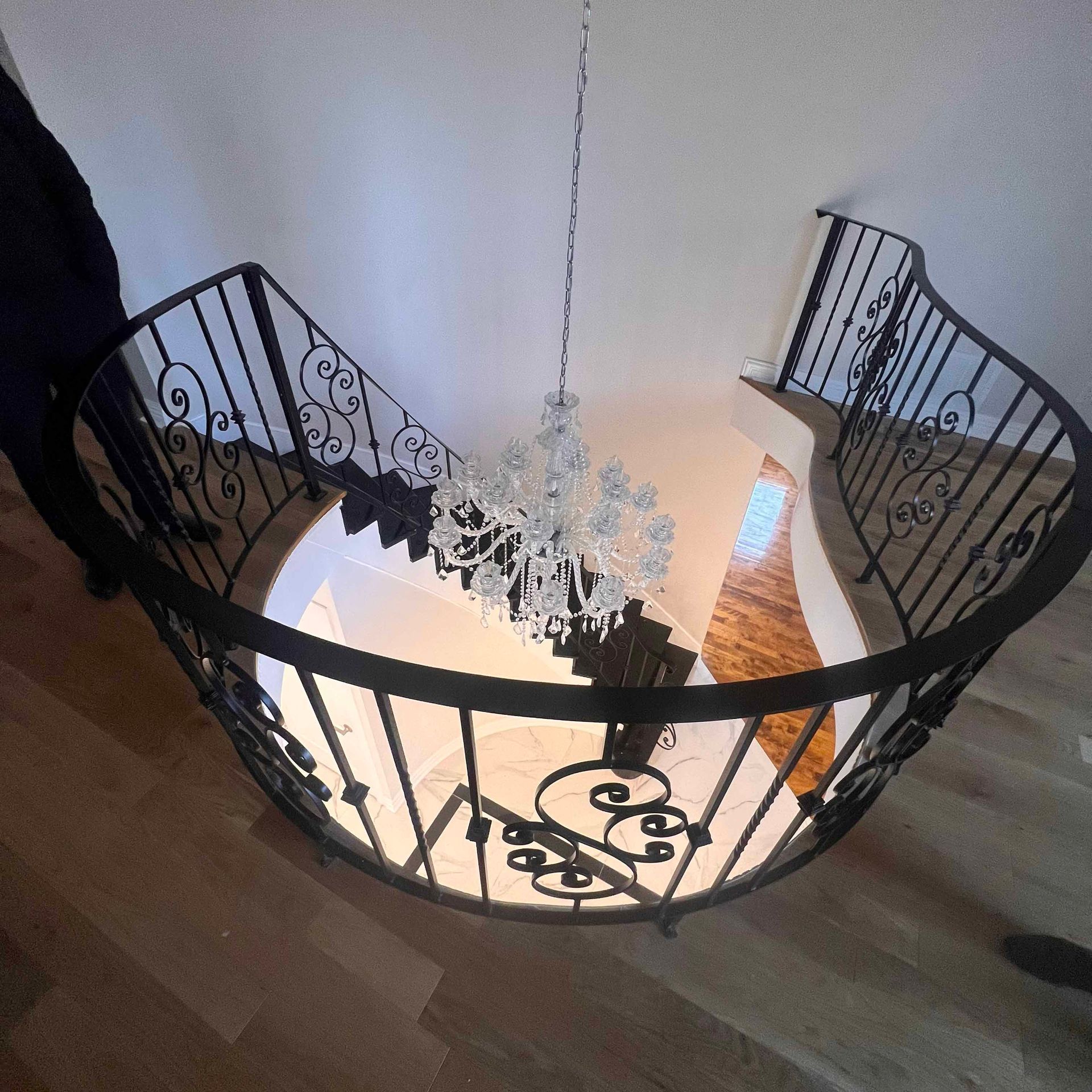A spiral staircase with a chandelier hanging from the ceiling