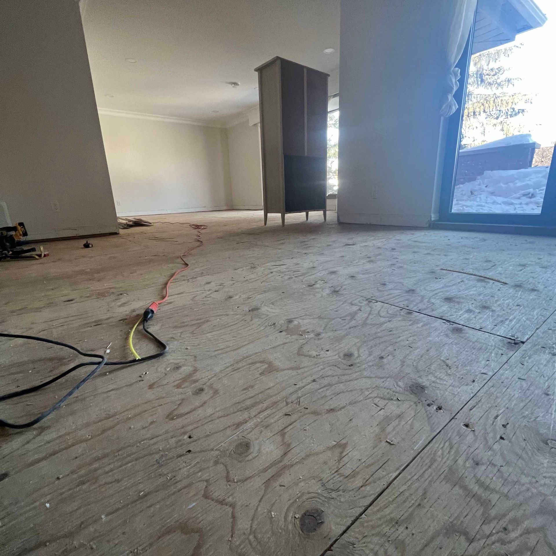 A room with a wooden floor and a window.