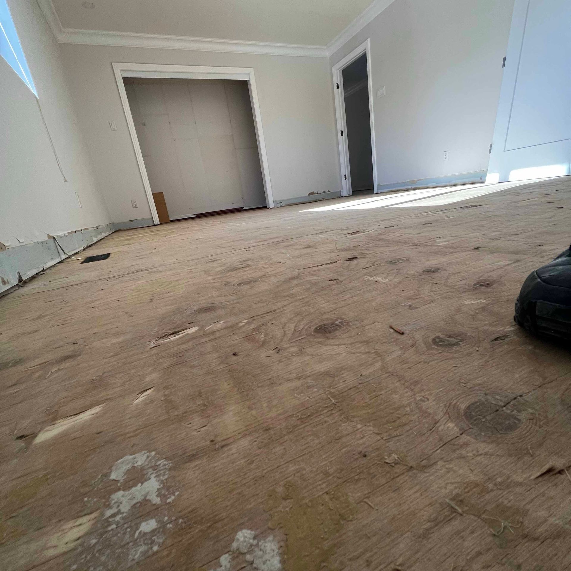 A person is standing on a wooden floor in a room.