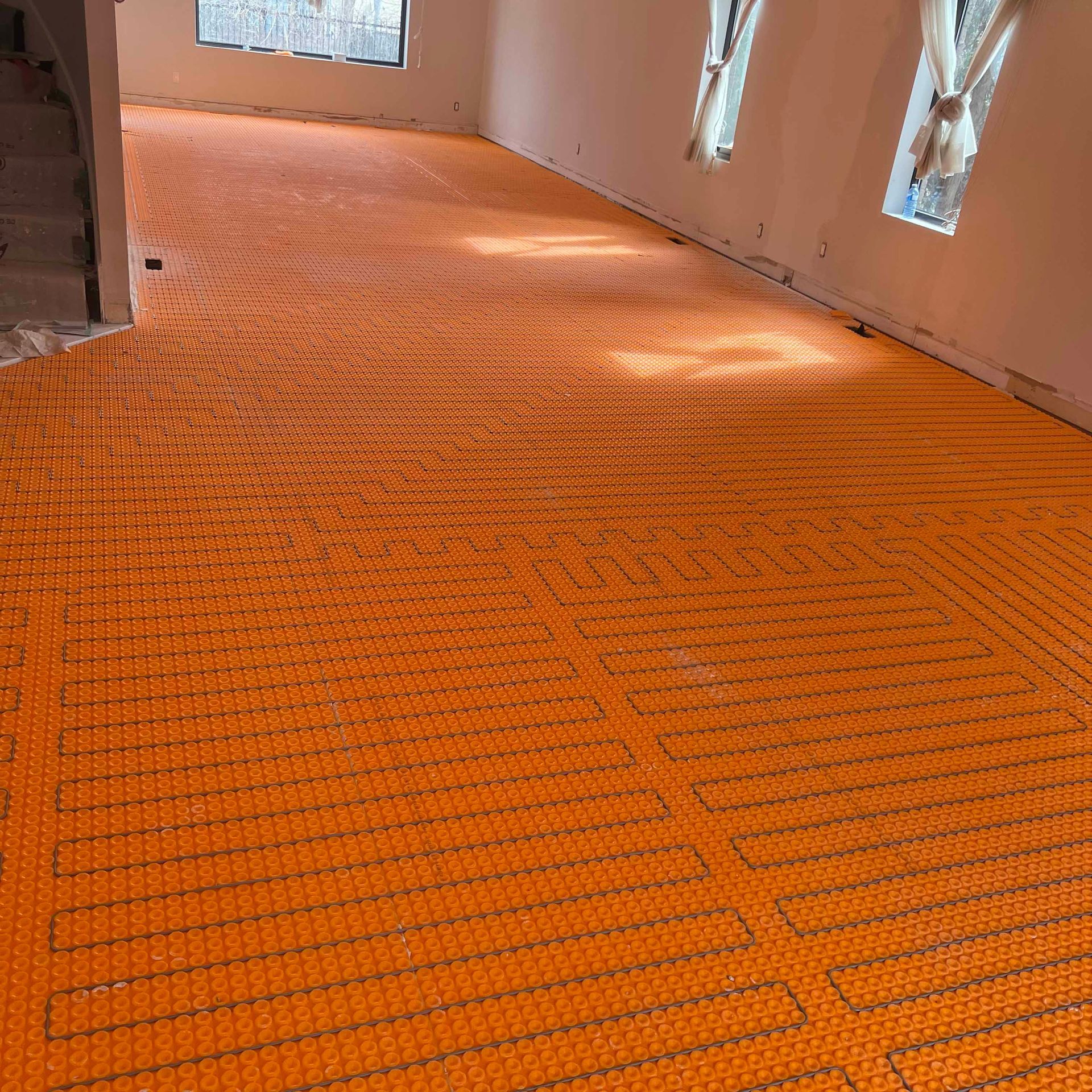 A large room with a lot of windows and an orange floor.