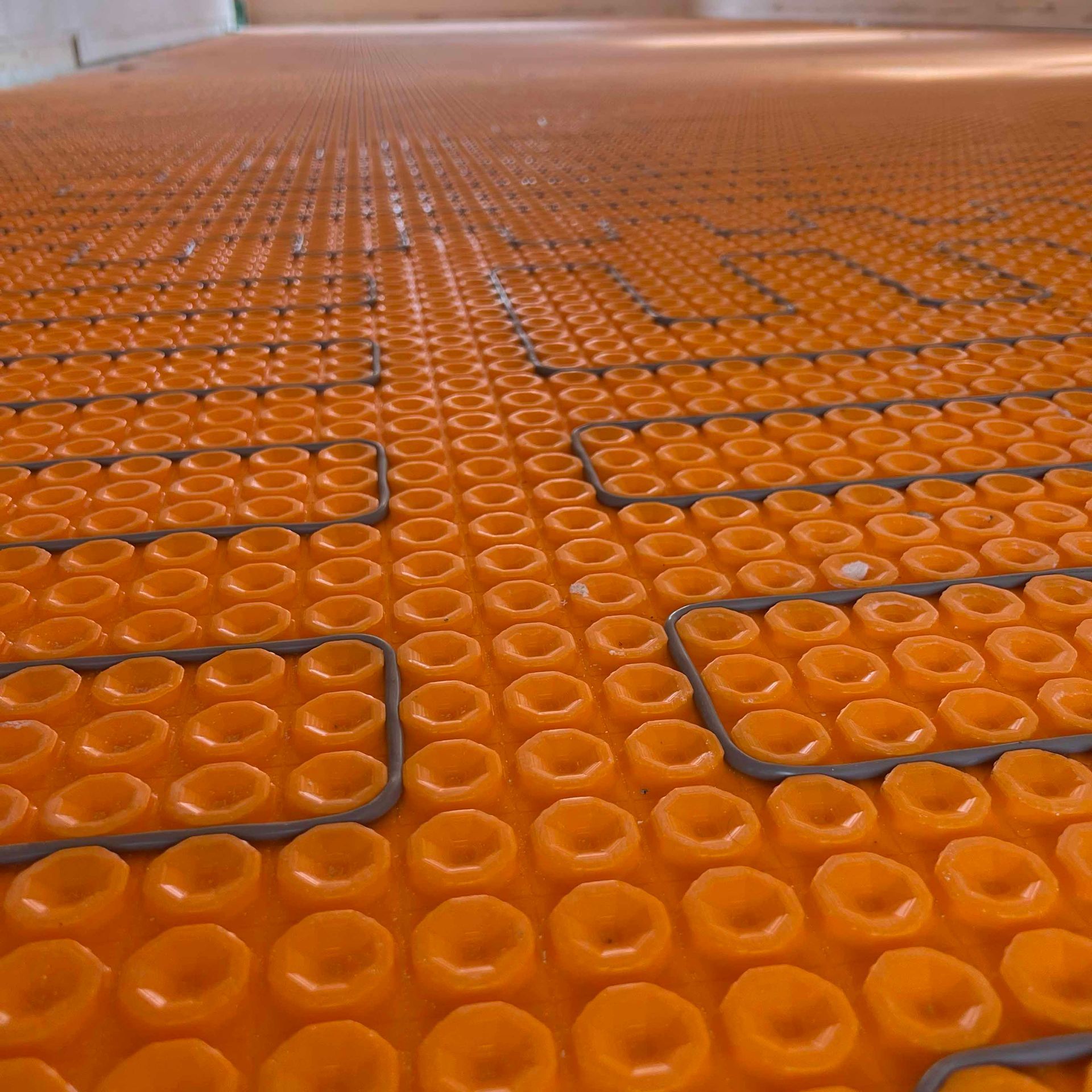 A close up of an orange floor with holes in it.