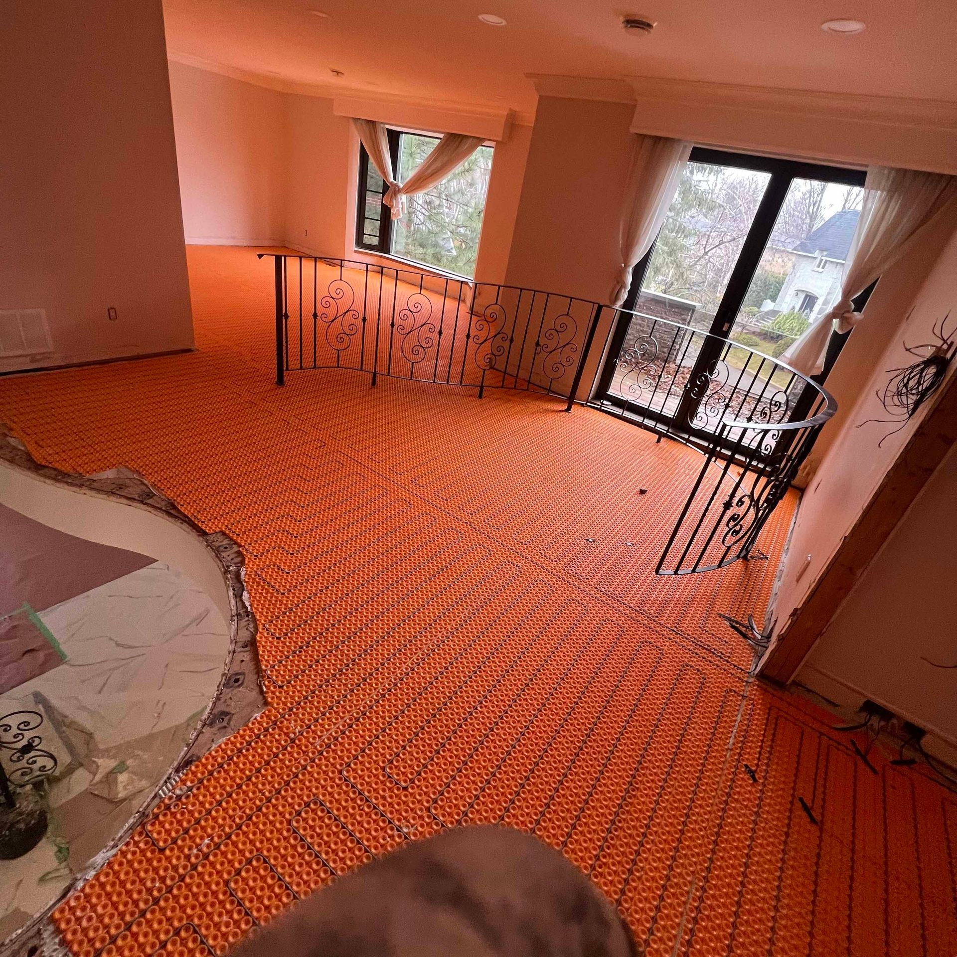 A room with an orange carpet and a staircase