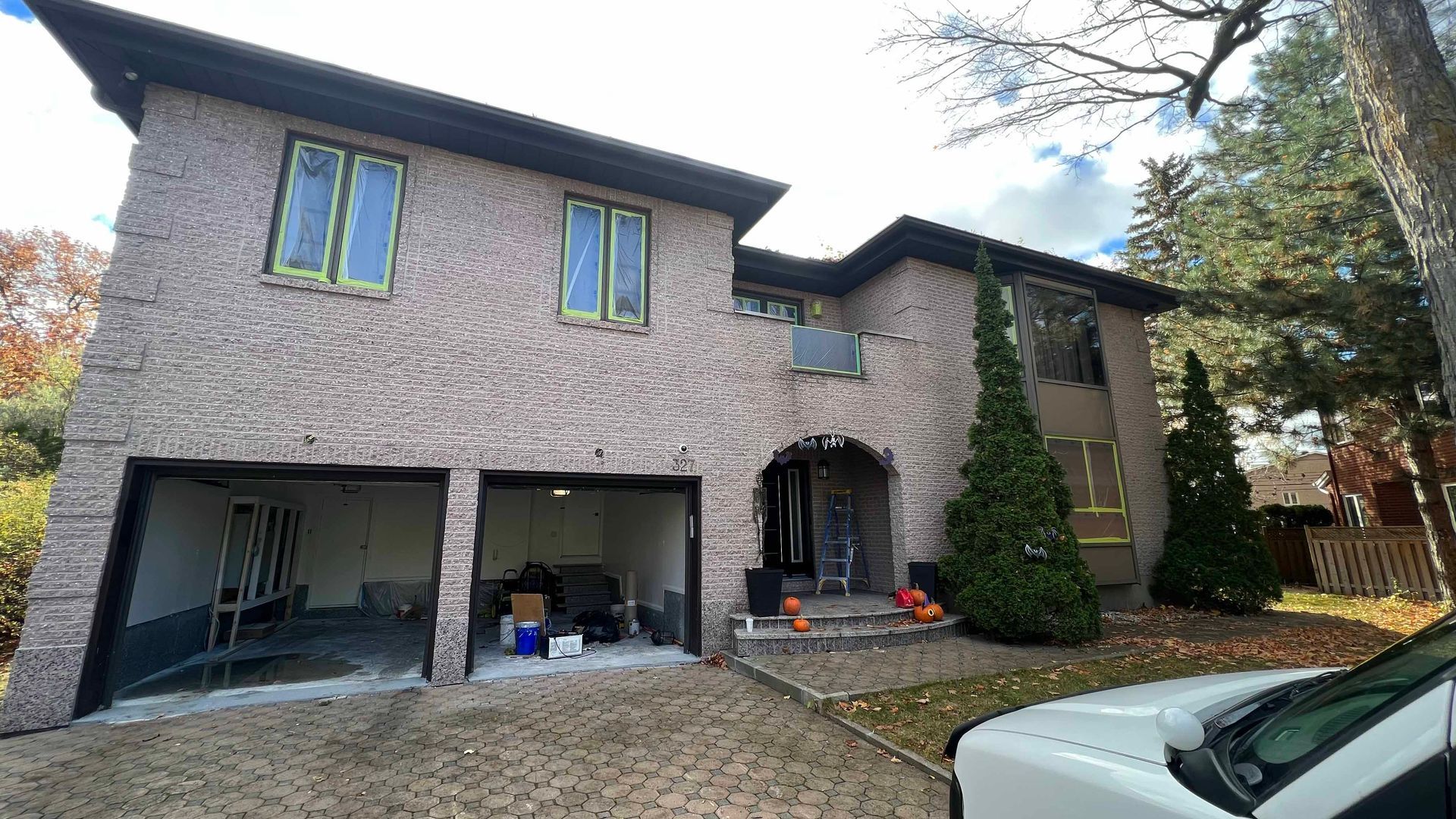 A large brick house with a white truck parked in front of it.