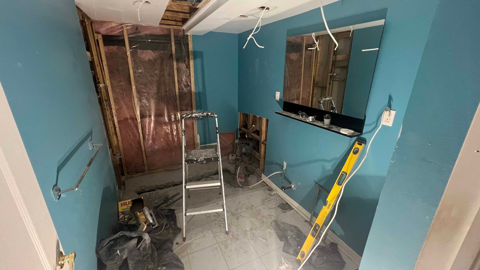 A room with blue walls and a ladder in it.