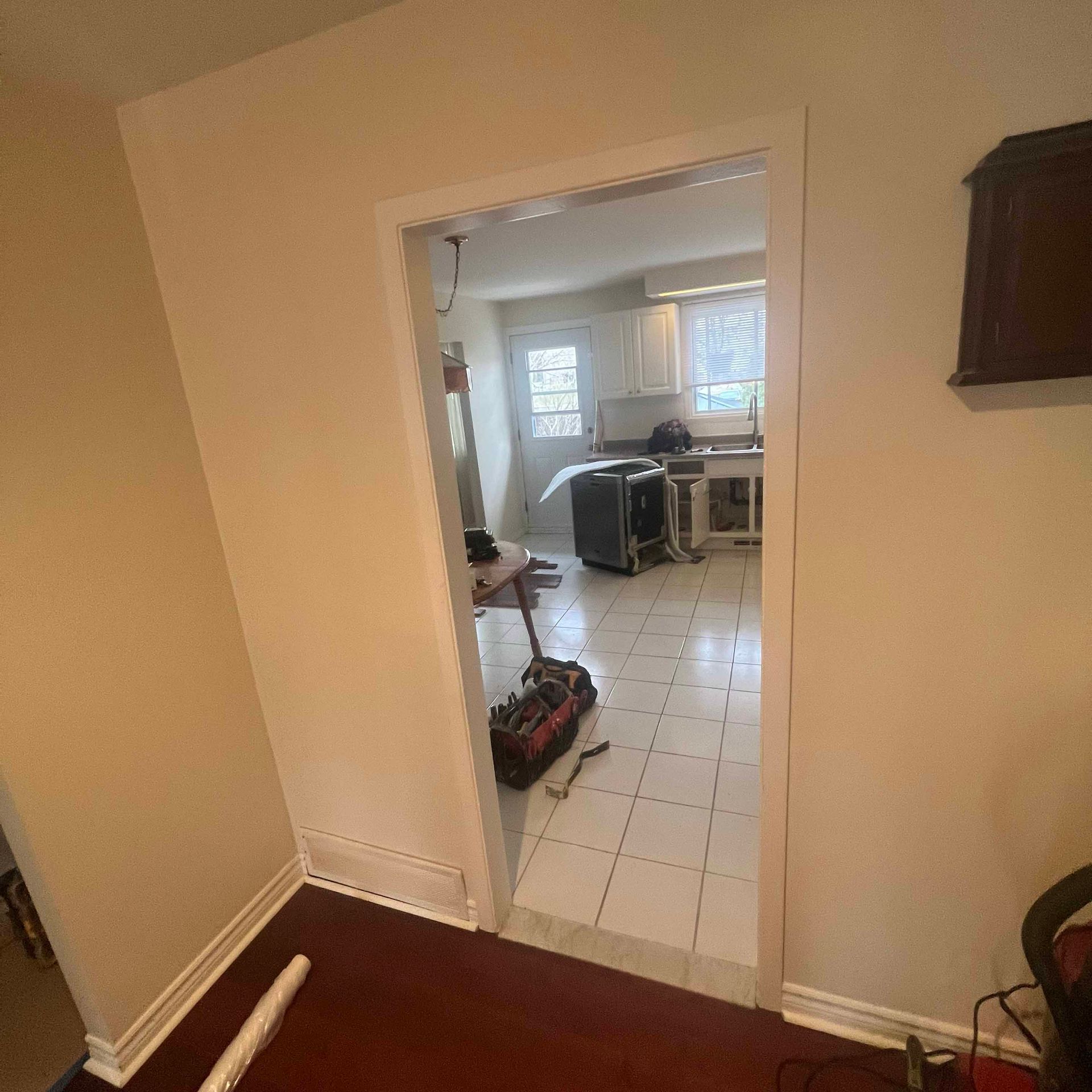 A doorway leading to a kitchen with a vacuum cleaner on the floor.