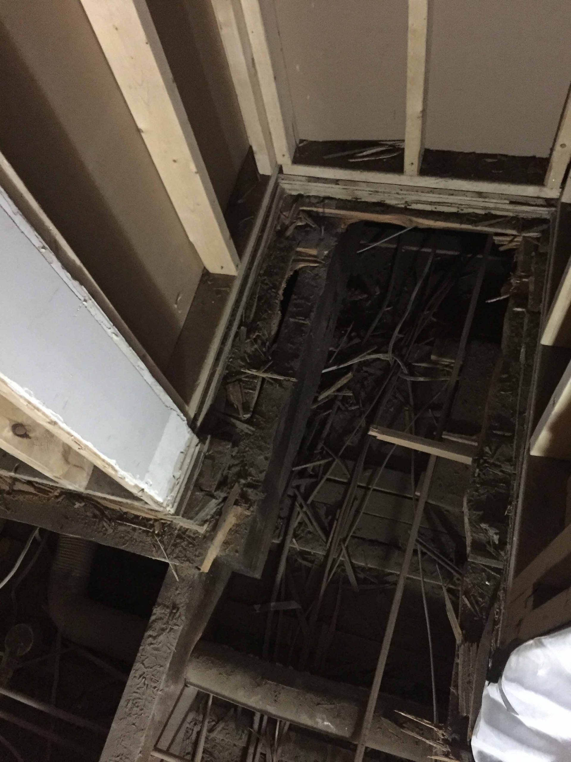 A person is standing in a hole in the floor of a building.