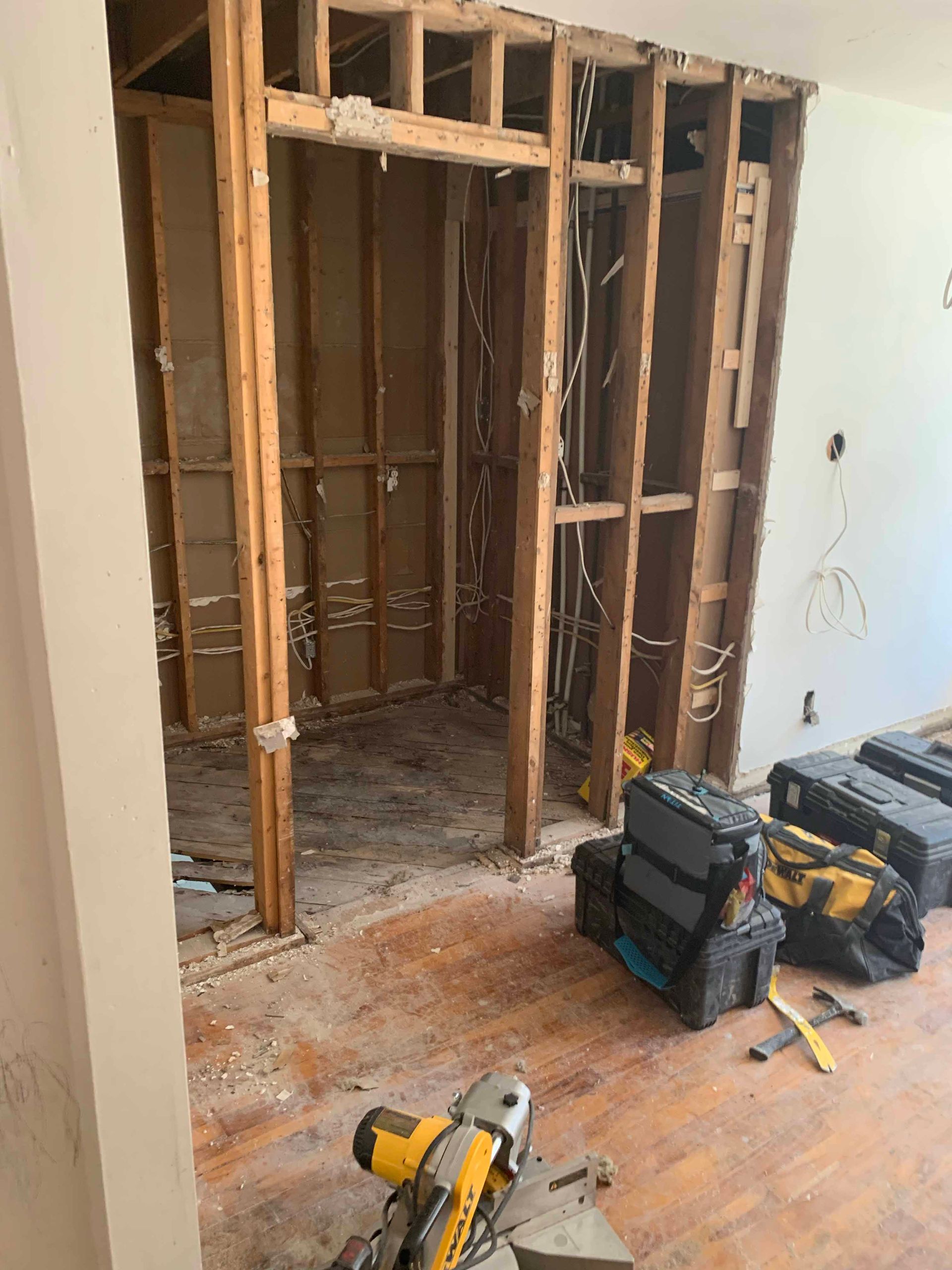 A room under construction with a circular saw in the middle of it.