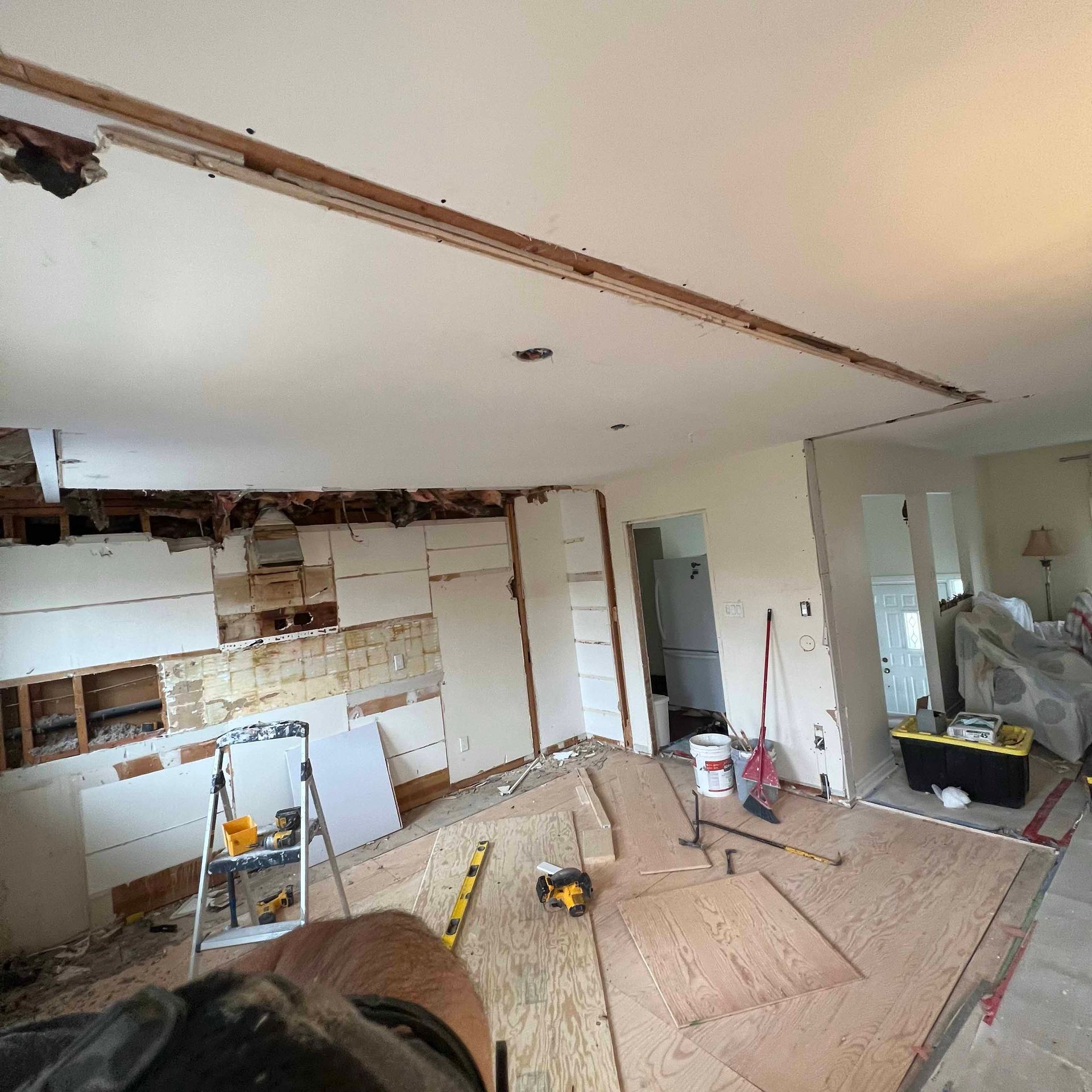 A living room is being remodeled with a ladder and tools.