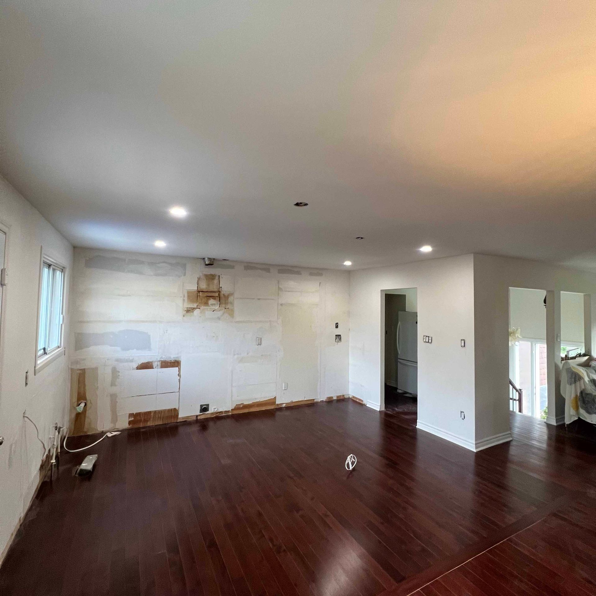 A living room with hardwood floors and white walls.