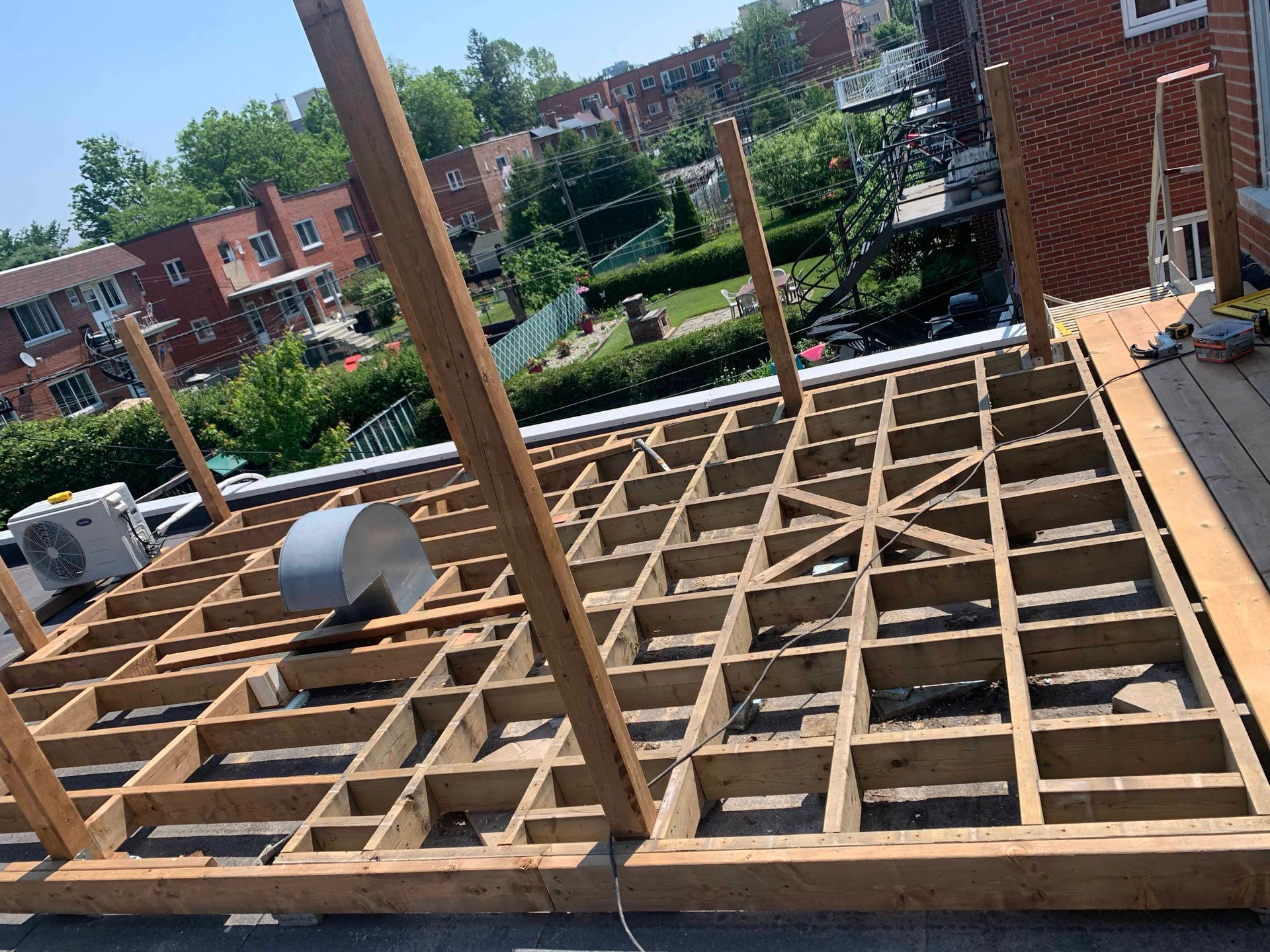 A wooden deck is being built on the roof of a building.