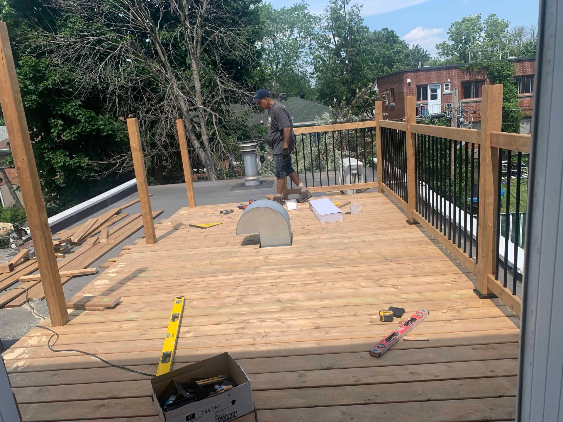 A man is standing on top of a wooden deck.