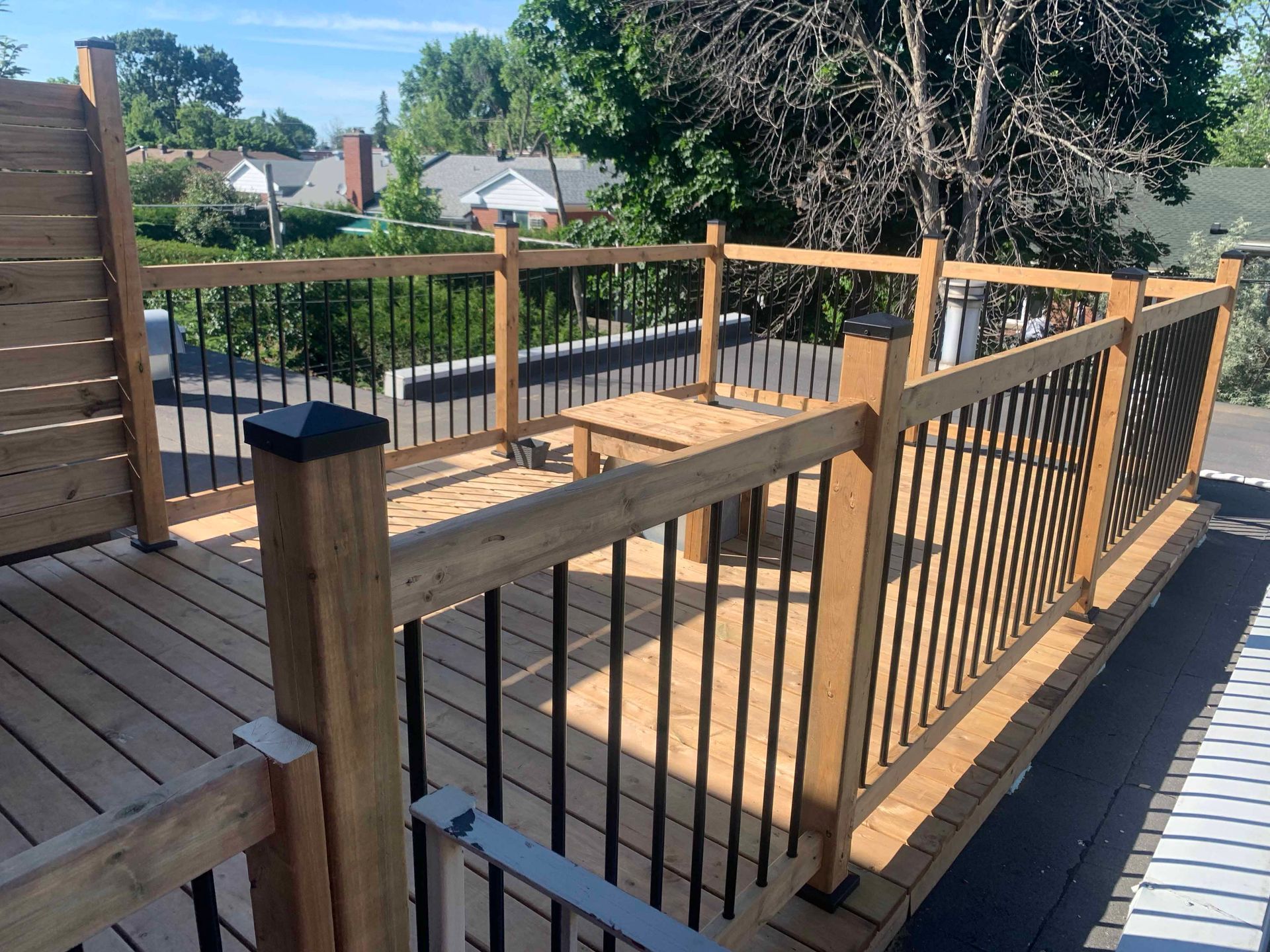 A wooden deck with a metal railing and a table.