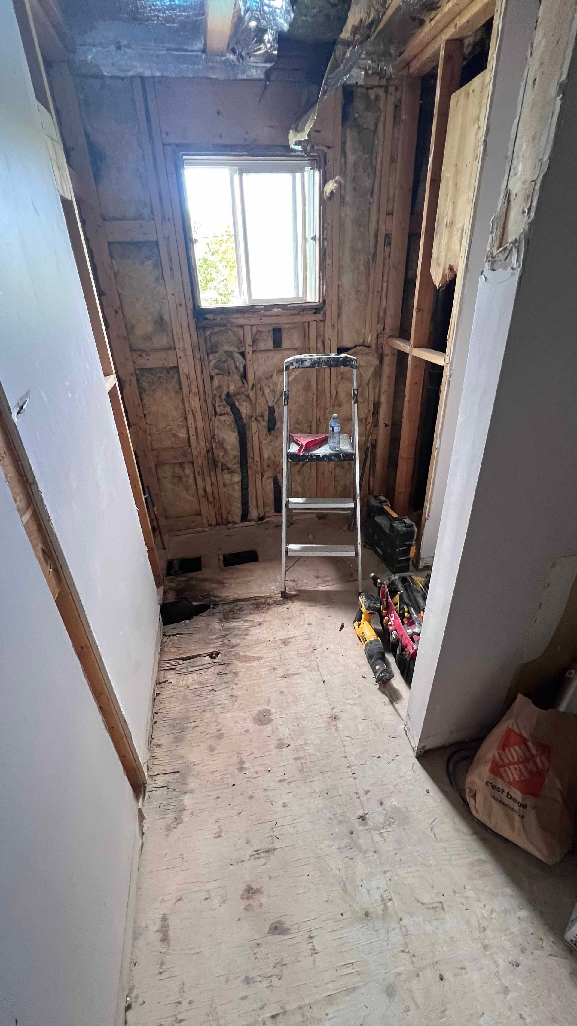 A room with a ladder in it and a window.