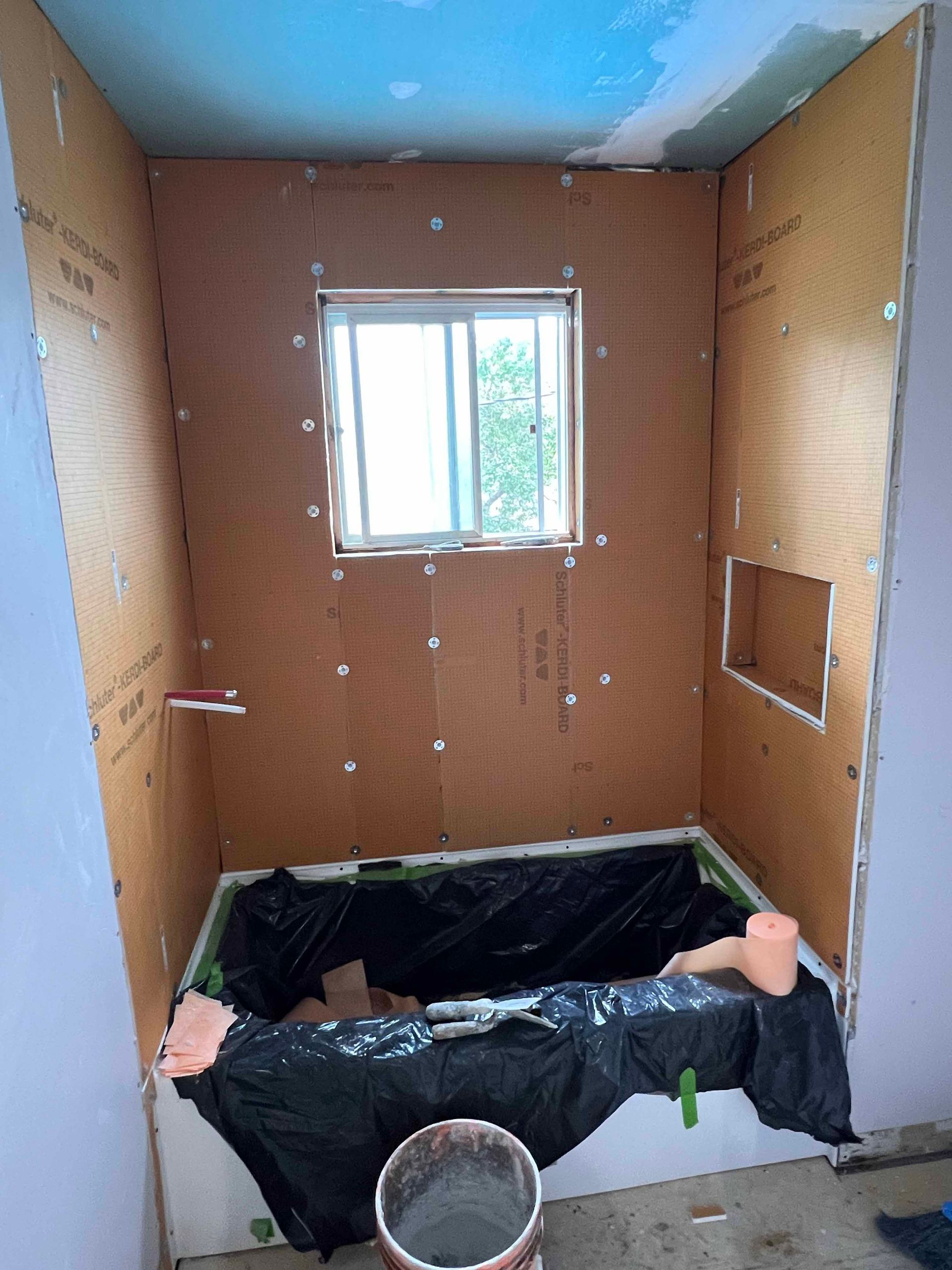 A bathroom under construction with a tub and a window
