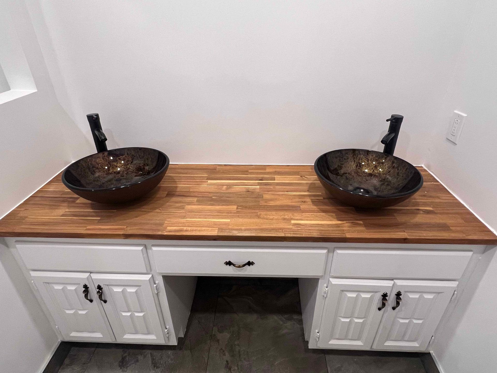 A bathroom with two sinks on a wooden counter top.