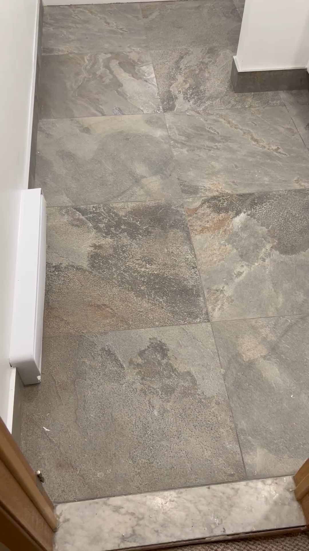 A close up of a tiled floor next to a door.