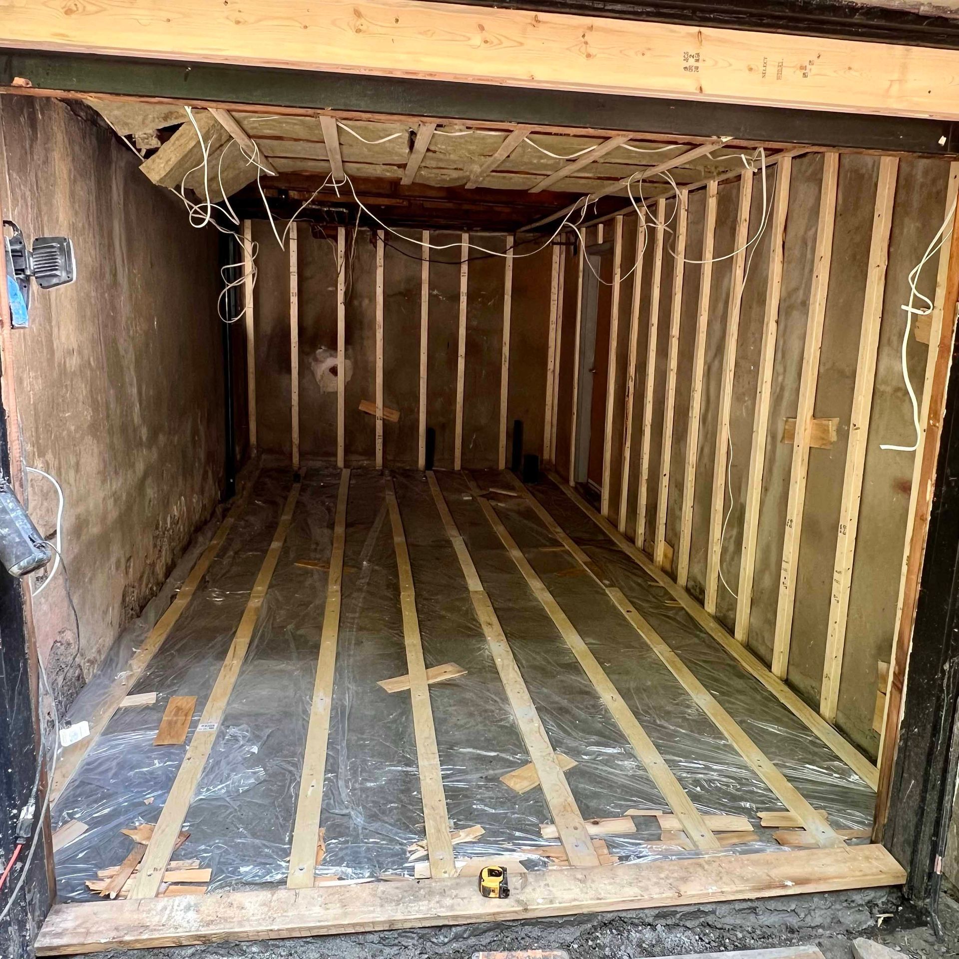 A garage is being remodeled with a wooden floor