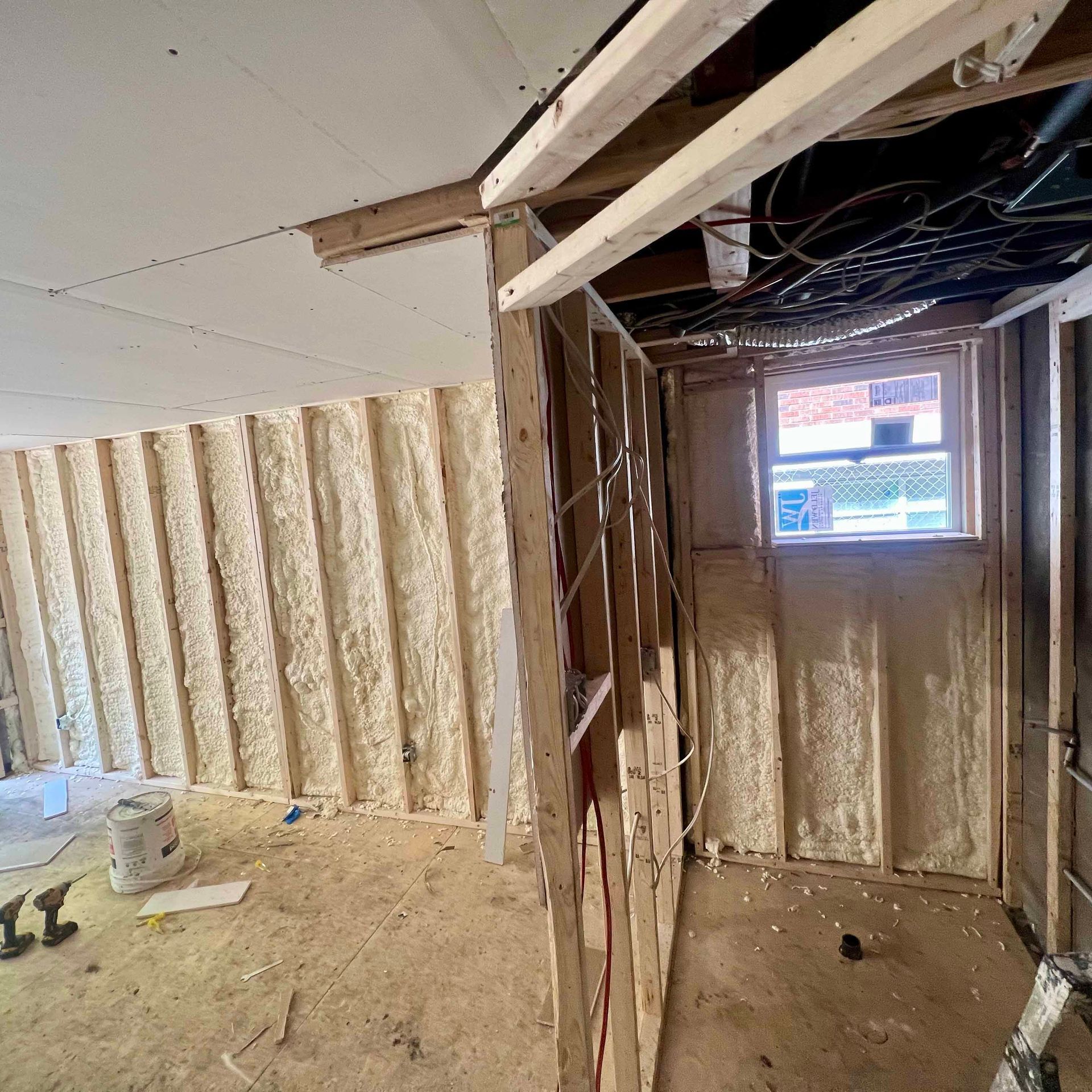 A room with a window and a ladder in it is being built.