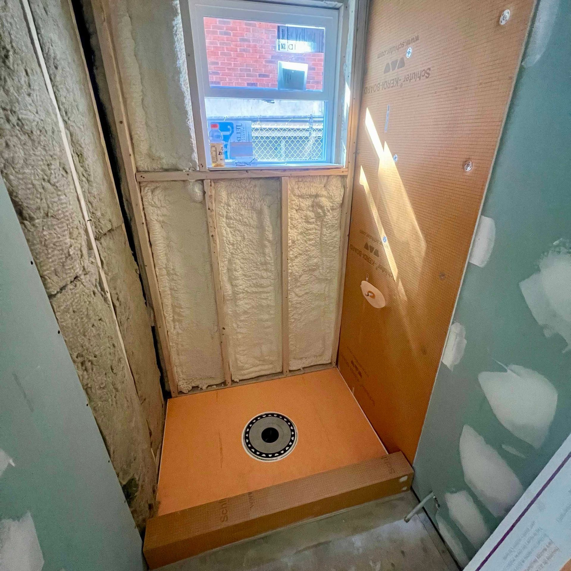 A bathroom under construction with a window and a toilet