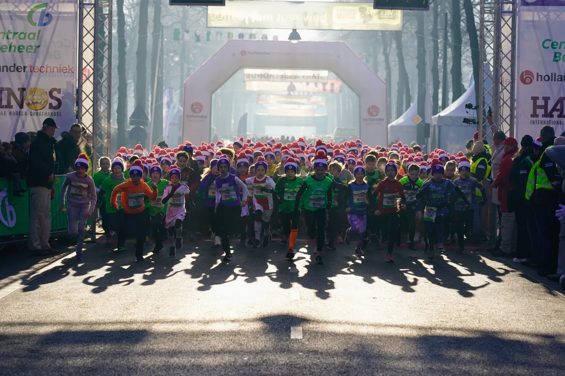 Groep hardlopers vertrekt bij de start van de Midwinter Marathon Apeldoorn in de ochtendzon.