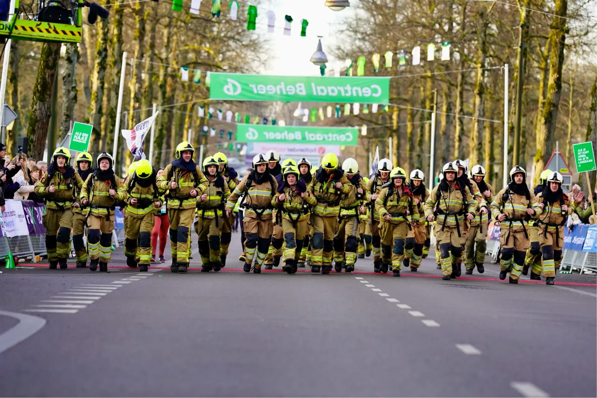 Brandweerteam loopt gezamenlijk richting finish tijdens de Midwinter Marathon Apeldoorn.