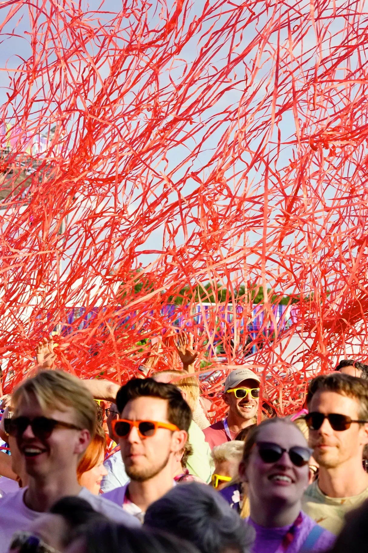 Publiek met rood confetti tijdens optreden op Achmea Festival Rosmalen, sfeerfotografie van het evenement.